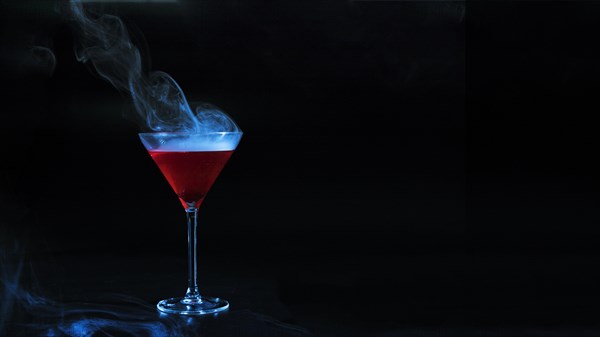 Wineglass with red smoky liquid