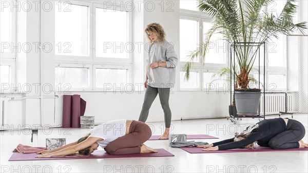 Teacher watching women stretching
