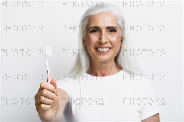 Smiley mature woman proud her toothbrush