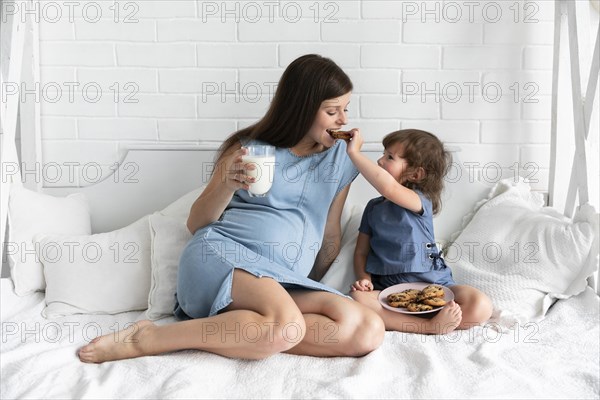 Mother daughter eating chocolate cookies