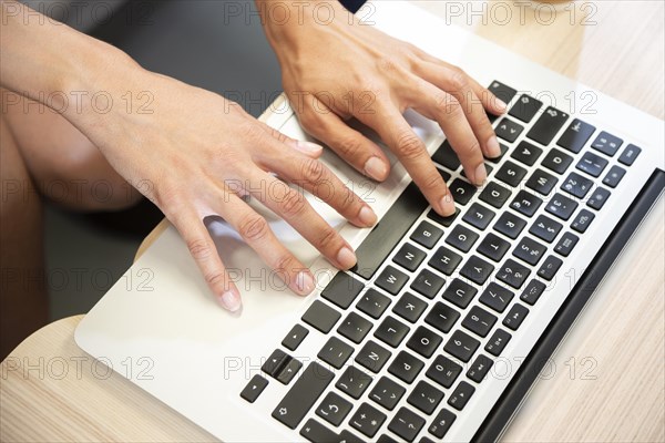 Hand typing laptop top view