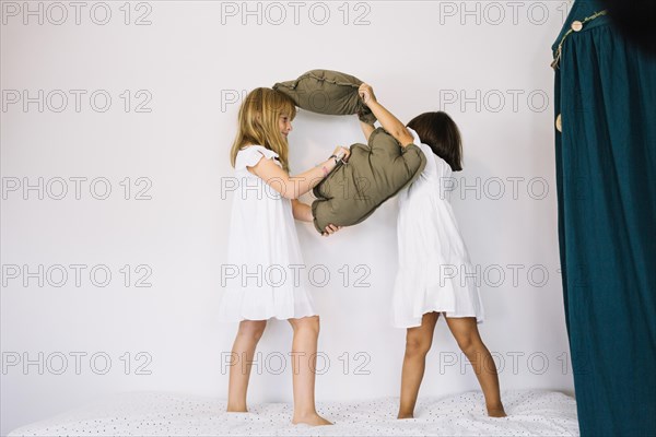Girls fighting with pillows