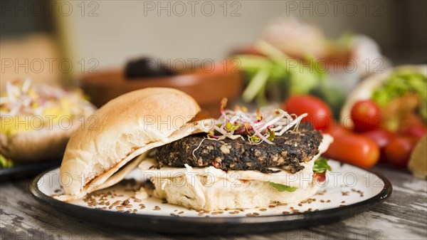 Veggie quinoa burger with sprouts flax seeds white plate