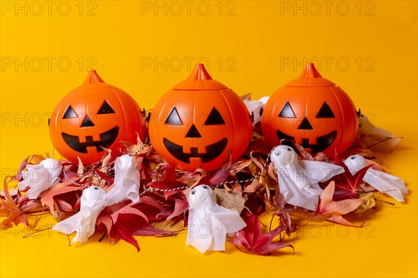 Halloween orange pumpkins on a yellow studio background