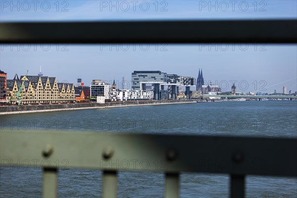 View of the city of Cologne and the Rhine through the railing of the South Bridge with Rheinauhafen