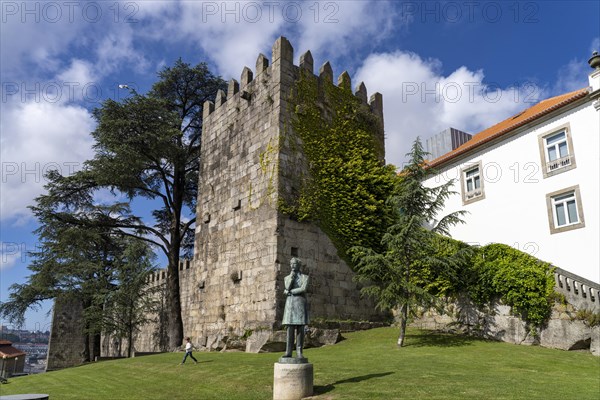 Statue of Arnaldo Gama in front of the tower of the historic city wall in Porto