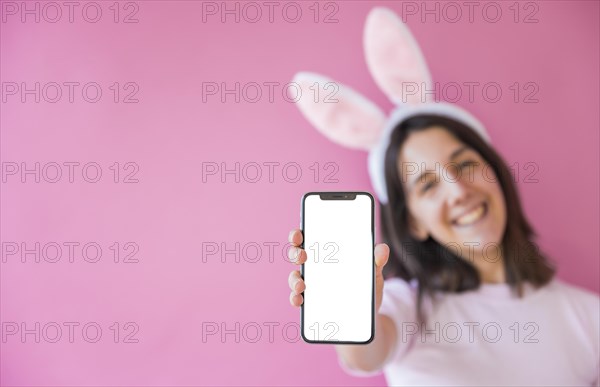 Woman bunny ears holding smartphone with blank screen