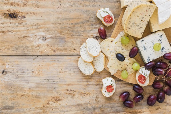 Cheese platters with grapes bread wooden desk