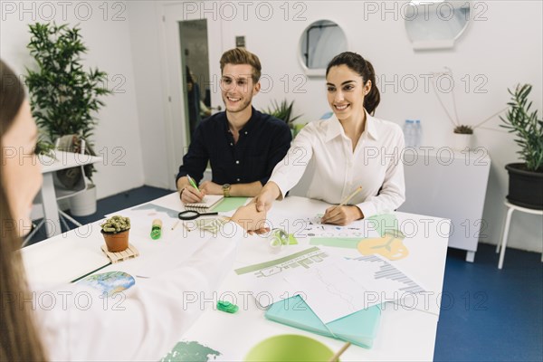 Two happy businesswoman shaking hands during business meeting