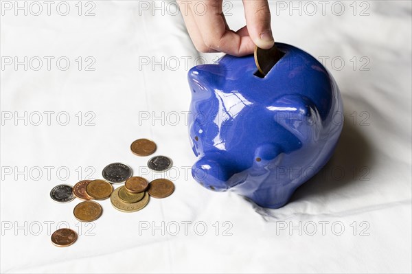 High view hand putting coins piggy bank