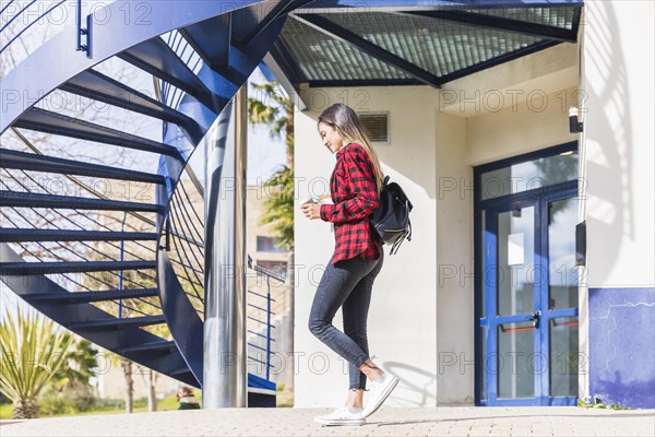 Side view teenage female student walking front university building