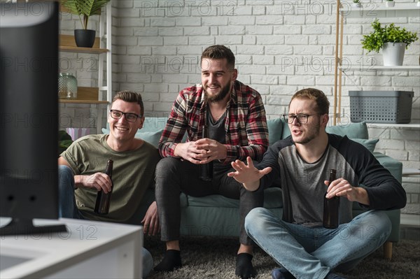 Front view male friends watching sports tv