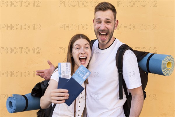 Side view smiley tourist couple with plane tickets passports