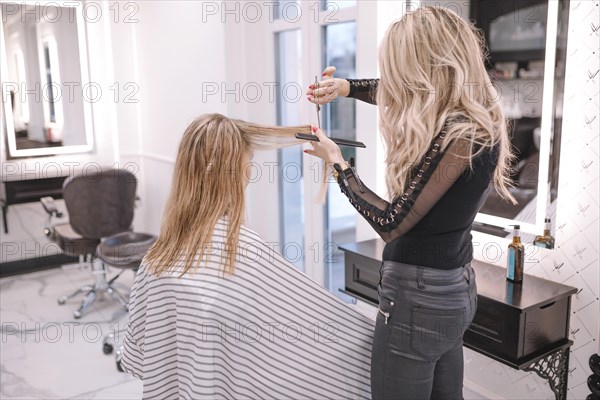 Stylist giving haircut young client