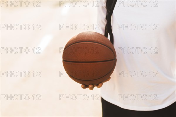 Unrecognisable man holding basketball front view