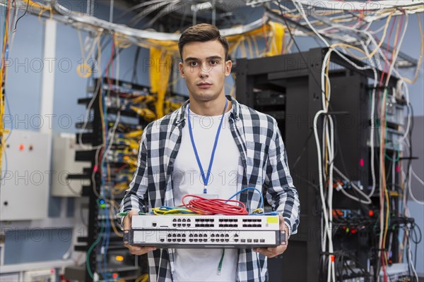 Young man holding ethernet switches