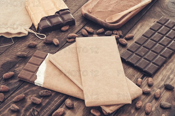 Dark chocolate bars with cocoa beans wooden table