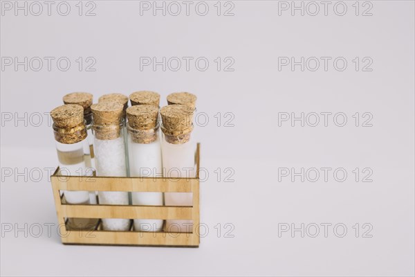 Beauty products test tubes wooden container white backdrop
