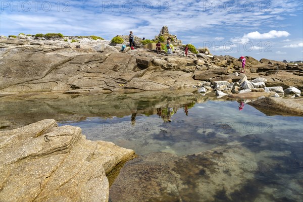 Natural pool among the rocks of the pink granite coast Cote de Granit Rose on the island Ile Grande