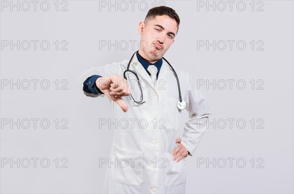 Doctor gesturing disapproval isolated. Unhappy doctor with thumb down isolated. Male doctor disapproving with fingers