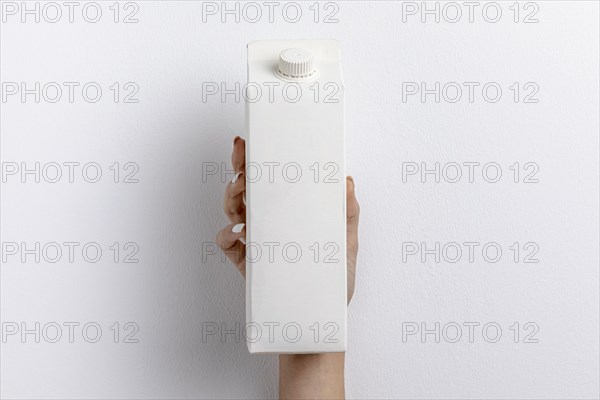 Front view hand holding simple milk carton