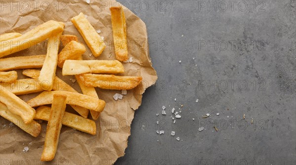 Top view french fries paper with salt copy space