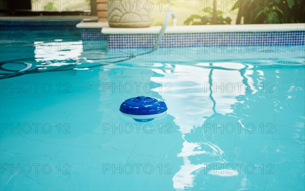 Chlorine dispenser in a beautiful swimming pool. A chlorine float in a swimming pool. Dosing float for swimming pool chlorination