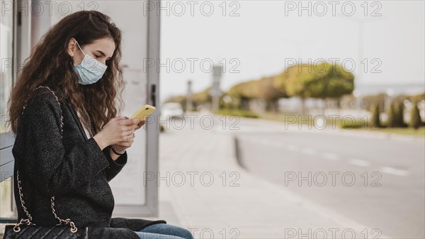 Woman waiting bus wearing medical mask