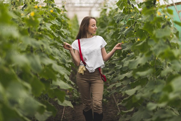 Woman taking care plants greenhouse