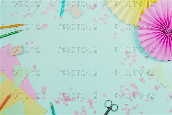 Circular paper fan with confetti colored pencils teal background