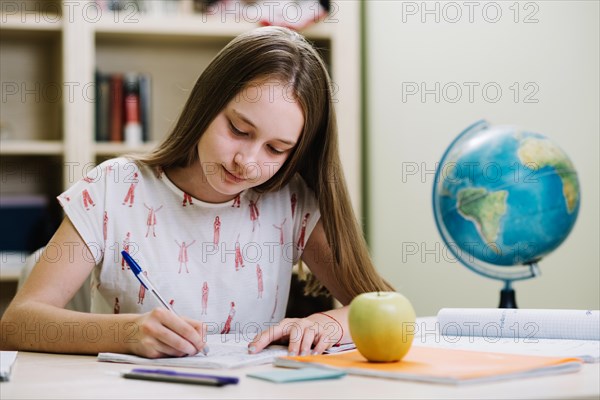 Content schoolgirl studying table