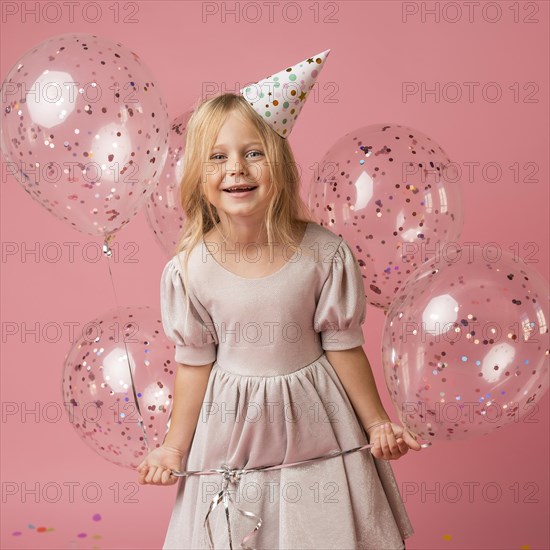 Little girl with balloons party hat