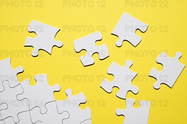 Separate white puzzle piece yellow backdrop