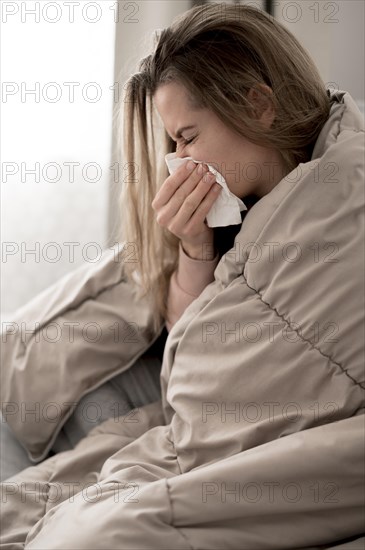 Young woman blowing her nose