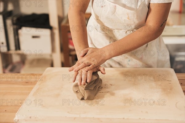 Woman s hand kneading clay table