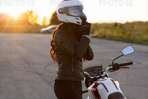 Side view woman taking off her helmet motorcycle