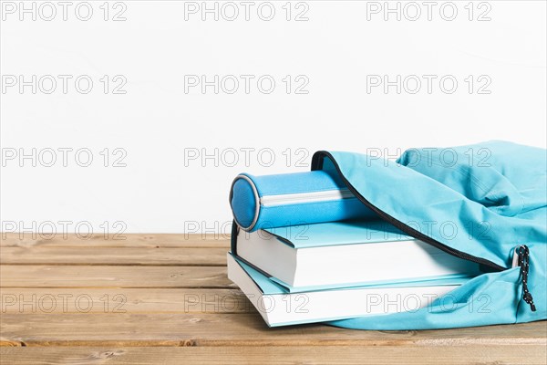 Blue books pencils case opening schoolbag wooden table