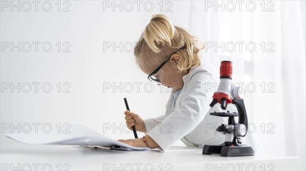 Side view cute toddler with lab coat microscope