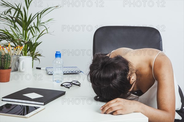 Tired businesswoman laying her head table