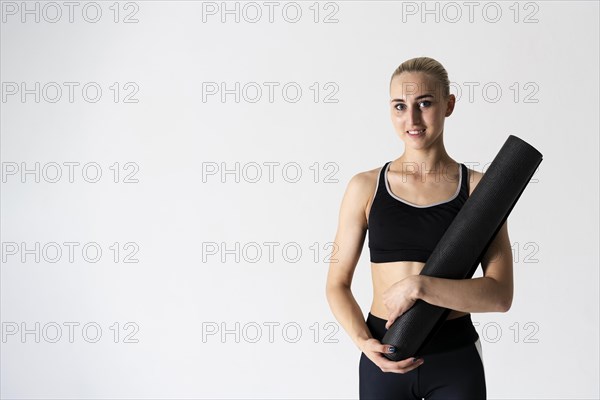 Medium shot woman with yoga mat copy space