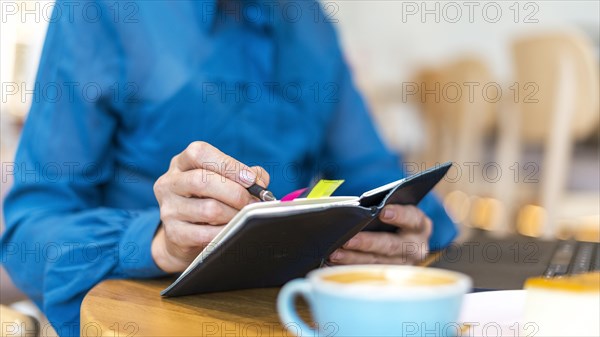 Older business woman working laptop writing agenda