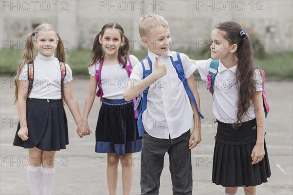 Boy gesturing thumb up while standing near girl