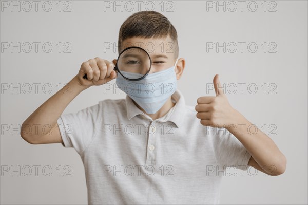Boy with medical mask using magnifier class