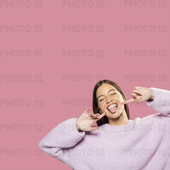 Beautiful young woman posing with pink wallpaper back