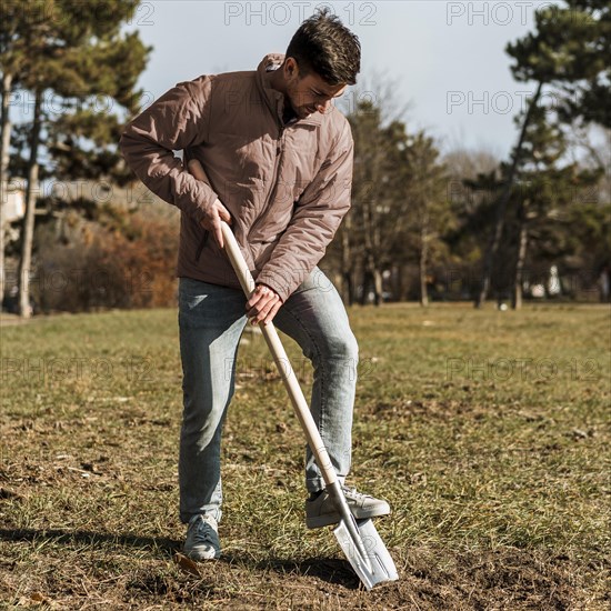 Man using shovel dig hole planting tree