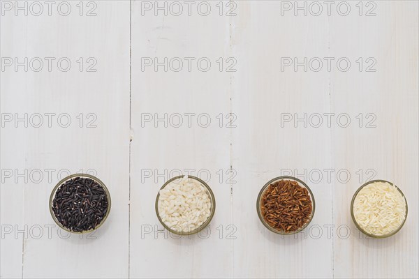 Colorful variety rice bowls arranged as border wooden background