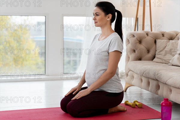 Side view pregnant woman doing yoga