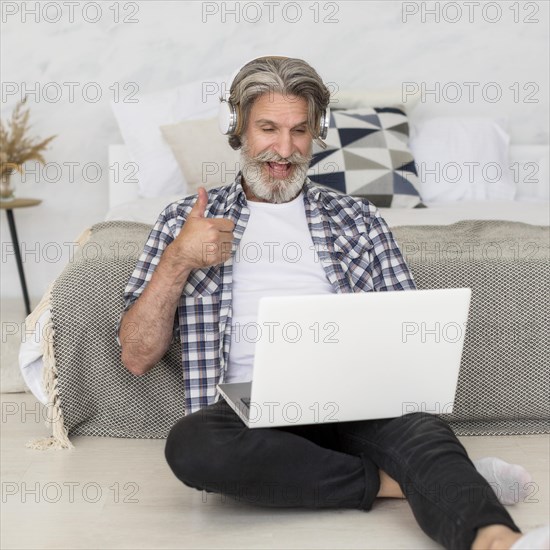 Teacher talking laptop sitting floor