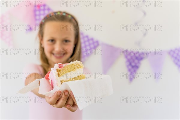 Cute smiling girl giving cake slice birthday part