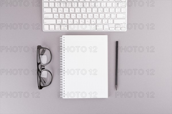 Pencil near notebook keyboard eyeglasses